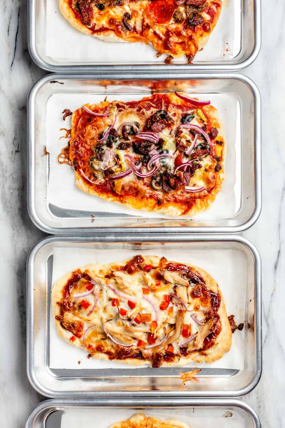 Surtido de pizzas hechas con 30 minutos de masa de pizza en mini bandejas para hornear