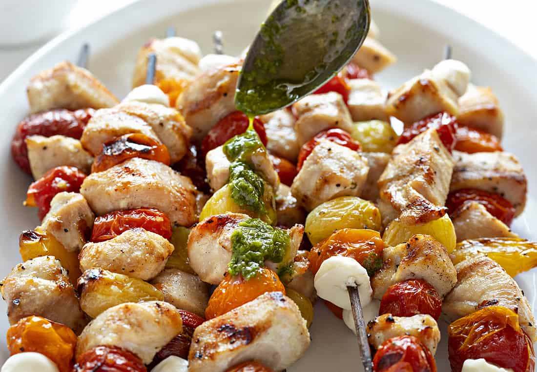 Brochetas de pollo Caprese rociadas con pesto de lim&oacute;n