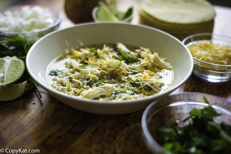 un tazón de pollo con frijoles blancos y varios ingredientes a su alrededor
