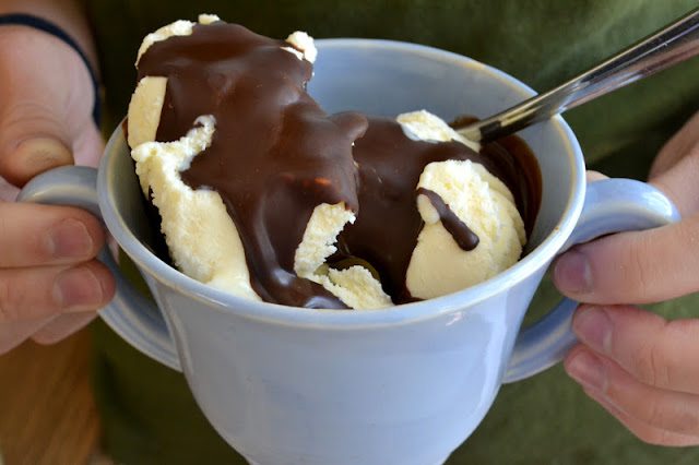 Foto de manos sosteniendo una taza de helado con c&aacute;scara m&aacute;gica casera.