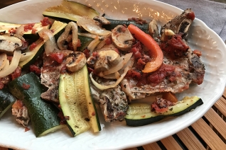 Cena de pan italiano con chuletas de cerdo y verduras