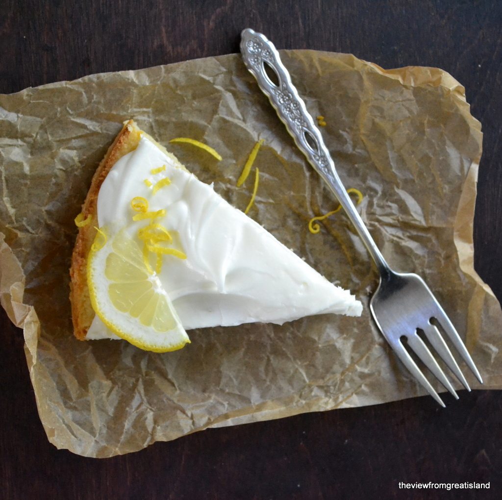 Fotografía aérea de un trozo de pastel de limón Meyer sin harina sobre papel pergamino con un tenedor.