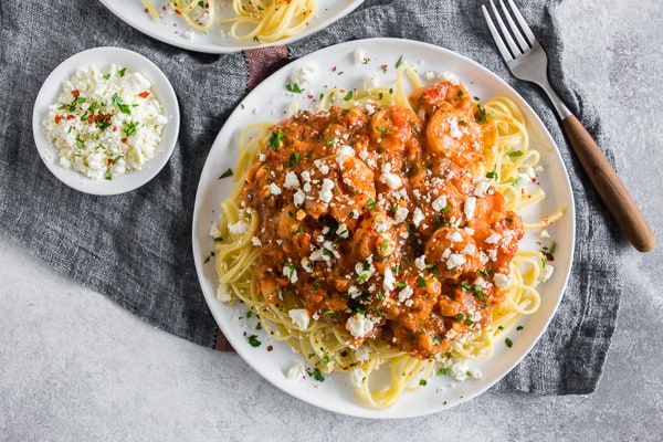 Esta pasta con camarones y queso feta es una comida llena de sabor durante la noche o para ocasiones especiales. Mi esposo creci&oacute; comiendo este plato y es su favorito de todos los tiempos. Camarones al ajillo mezclados con una salsa de tomate jerez con queso feta servida sobre pasta perfectamente cocida: &iquest;qu&eacute; es lo que no te gusta?