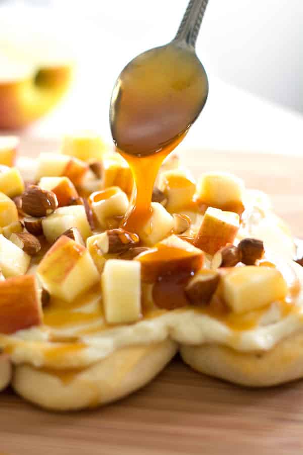 ¡Un postre único de pizza de manzana que puedes separar! Hecho con una corteza de galleta, glaseado de queso crema picante, manzanas frescas, caramelo y nueces.