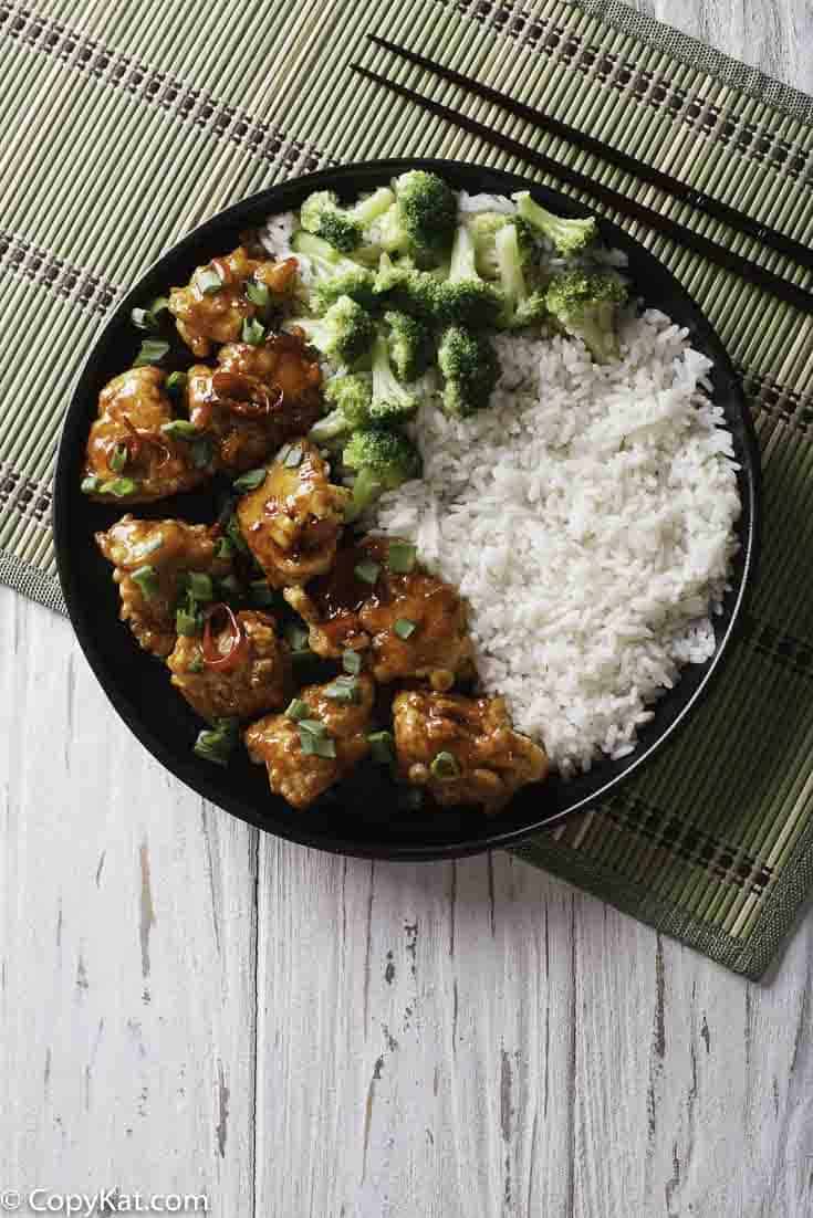 Un plato de pollo de General Tso con arroz y brócoli.