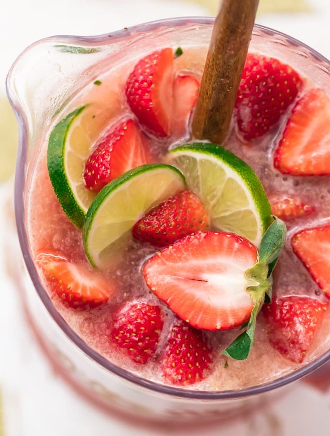 Jarra de margaritas con rodajas de fresa y lima encima
