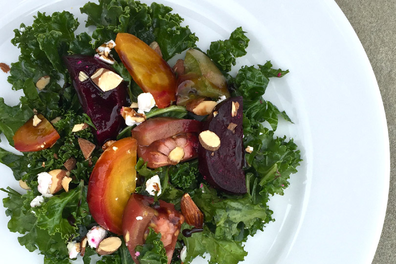 Ensalada de col rizada con remolacha asada, queso de cabra y tomates reliquia