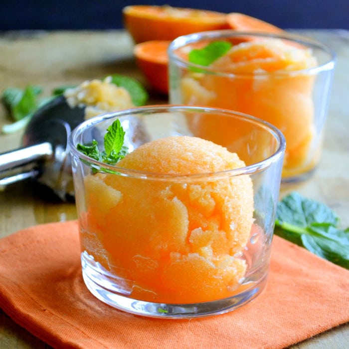 sorbete de mandarina saludable de un ingrediente en pequeños tazones de vidrio con ramitas de menta