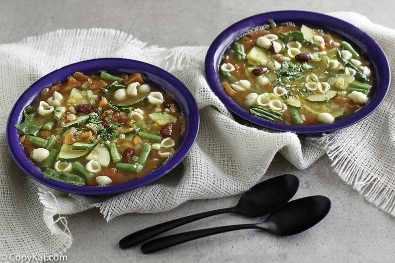 Dos tazones de sopa vegetariana minestrone. La sopa est&aacute; llena de verduras frescas y pasta.