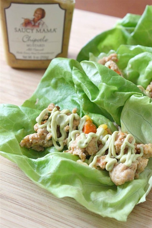 Estas tazas de lechuga con pollo chipotle son el almuerzo o la cena perfectos. Delicioso pollo molido aderezado con pimientos chipotle, mostaza marrón picante, pimientos rojos y maíz, todo envuelto en crujientes hojas de lechuga Bibb. Luego, para colmo, se rocía con crema agria de aguacate.