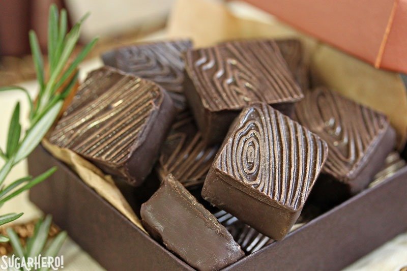 Trufas de frambuesa y romero: primer plano de trufas de frambuesa y romero cuadradas con un patr&oacute;n de grano de madera con manchas de oro