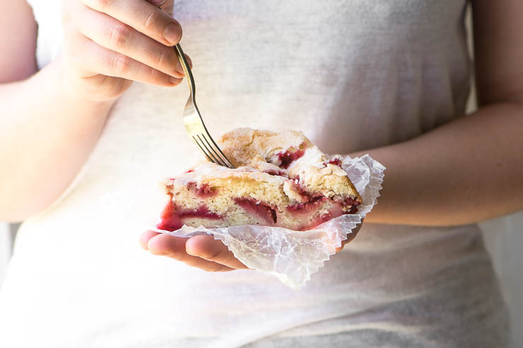 Chica sosteniendo un trozo de tarta de fresa y suero de leche