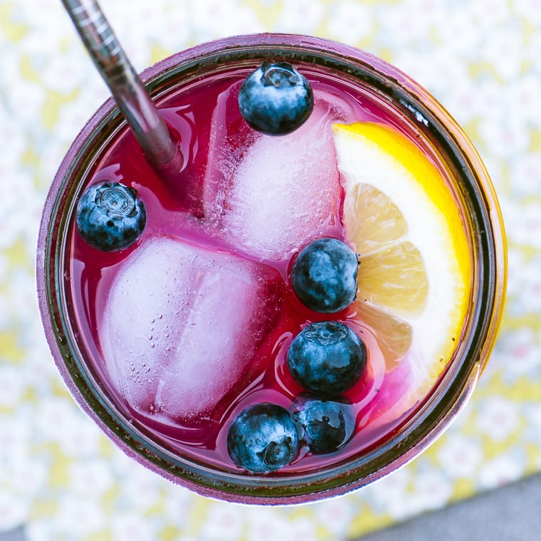 un vaso de limonada de ar&aacute;ndanos con bayas y rodaja de lim&oacute;n