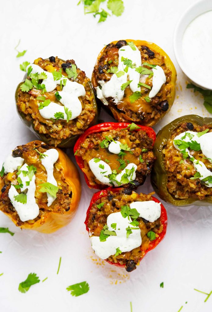 These slow cooker tex-mex stuffed peppers put a little twist on the original stuffed pepper recipe. They are made in the slow cooker and topped with amazing cilantro sour cream to complete this delicious and easy meal!