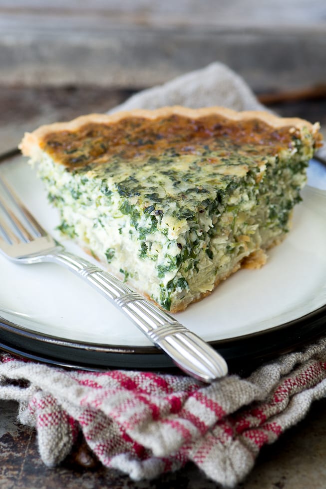 Quiche de alcachofas y espinacas en un plato con tenedor