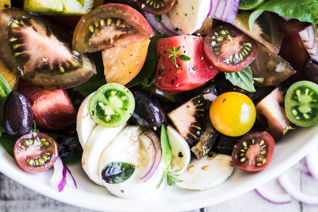 Ensalada caprese de tomate colorido reliquia en un taz&oacute;n blanco
