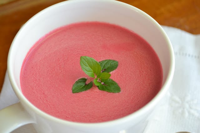 sopa de remolacha fr&iacute;a en una taza blanca, con una ramita de menta