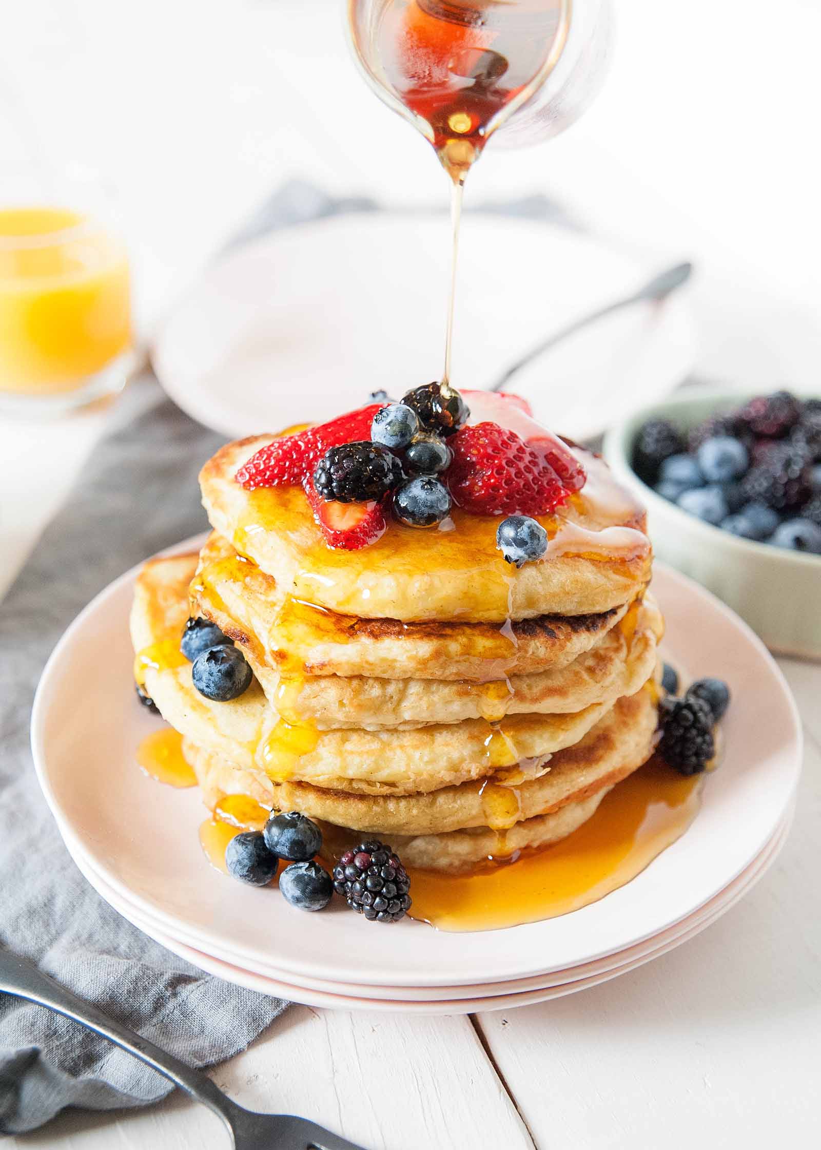 Best Pancake Mix - stack of panckes on pink plate with berries on top