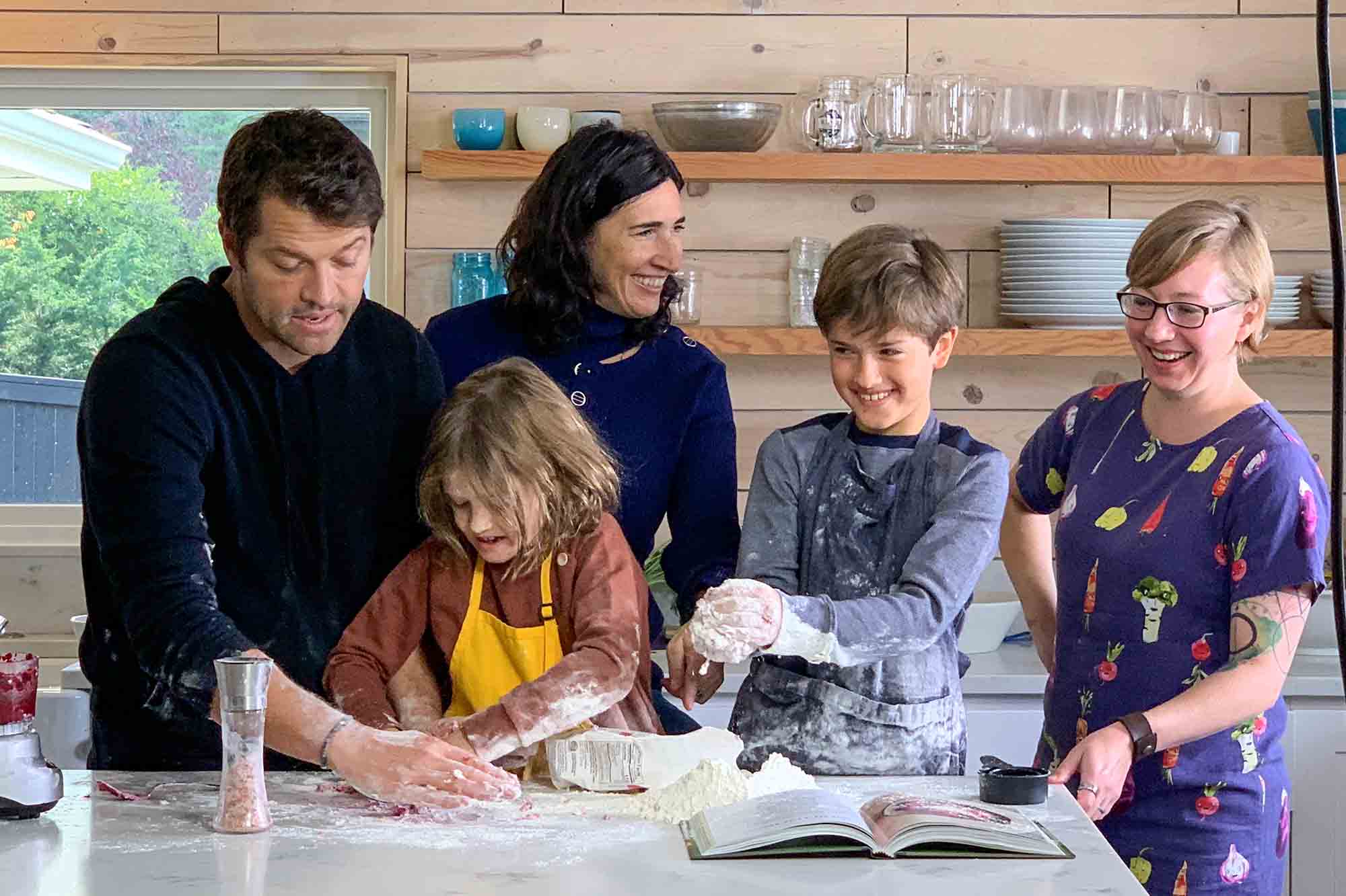 Misha and Vicki Collins with their kids and Emma Christensen making gnocchi