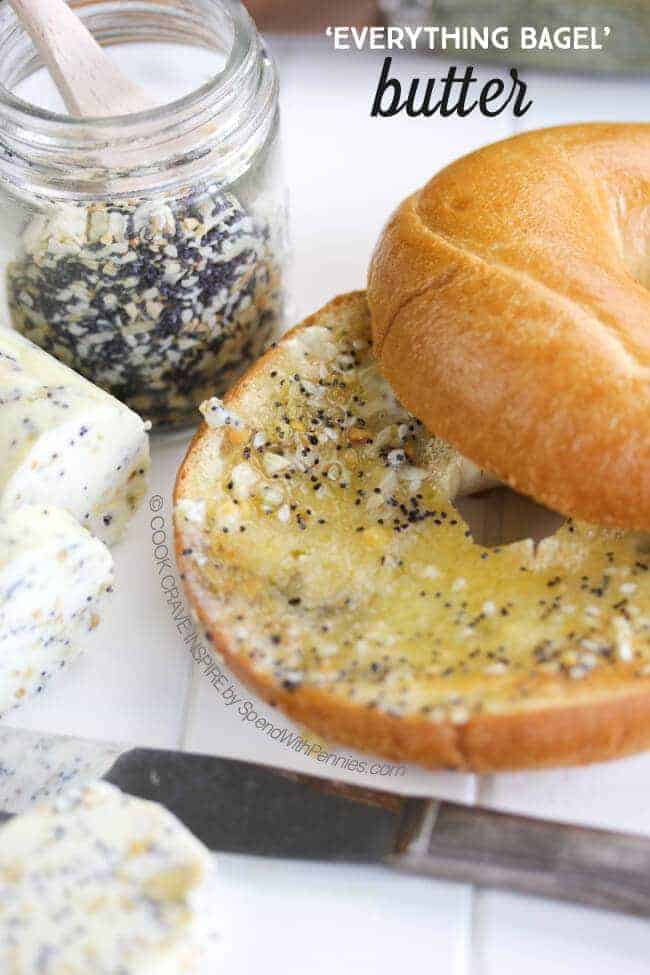butter and seasoning on a bagel with a butter knife