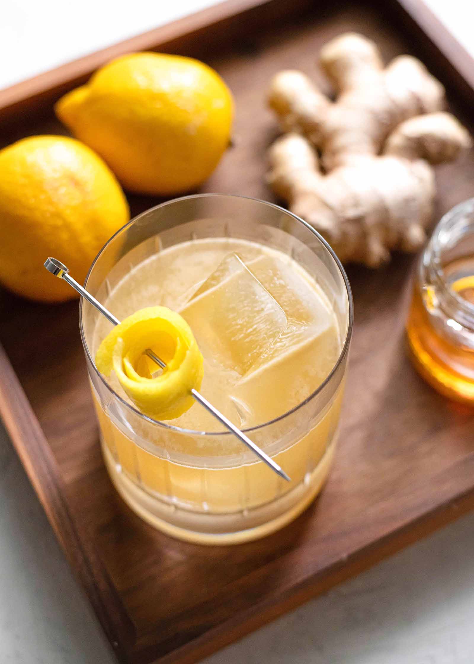 Penicillin Scotch cocktail on a wooden tray