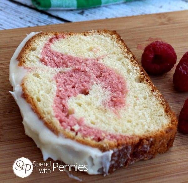 a slice of Copycat Starbucks Raspberry Swirl Pound Cake with the entire pound cake in the background