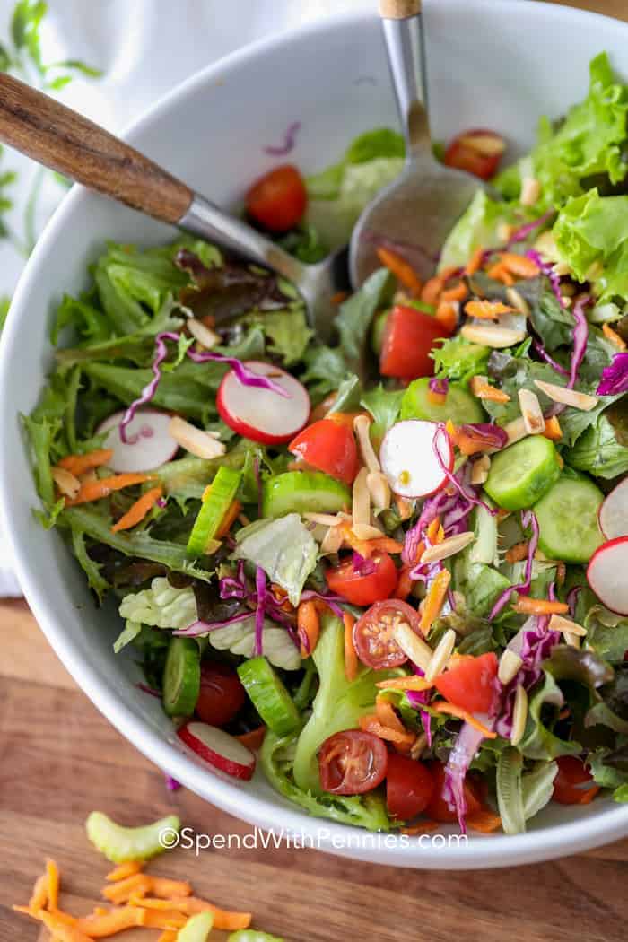 Tossed Salad in a white bowl with two spoons