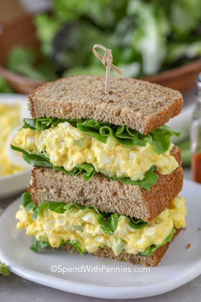 Egg salad sandwich on wheat bread on a white plate