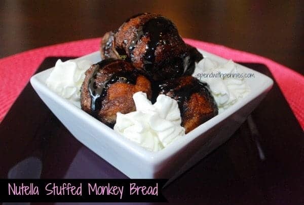 nutella stuffed monkey bread with whipped cream on a white plate