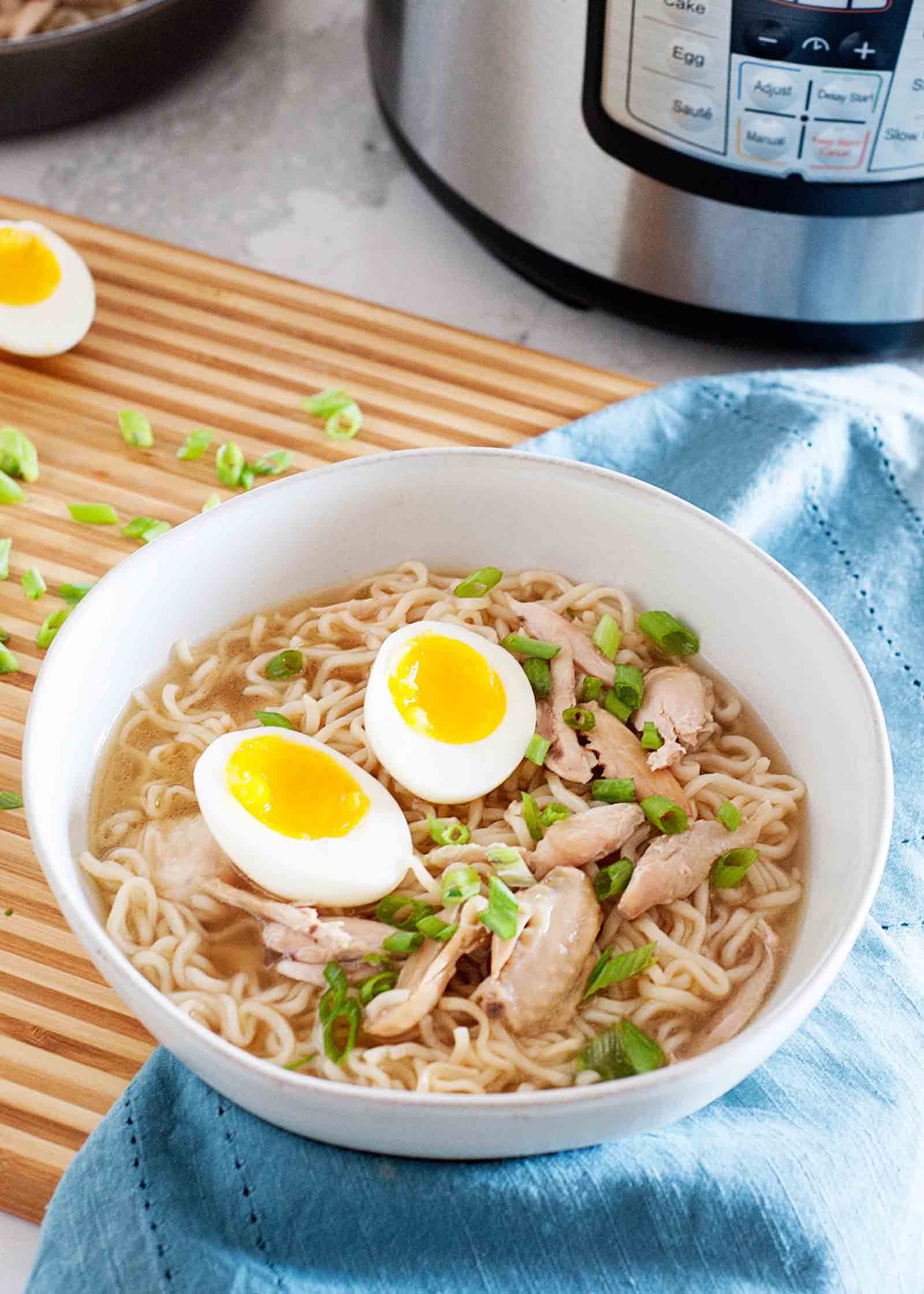 A bowl of Pressure Cooker Chicken Wing Ramen with an Instant Pot in the background