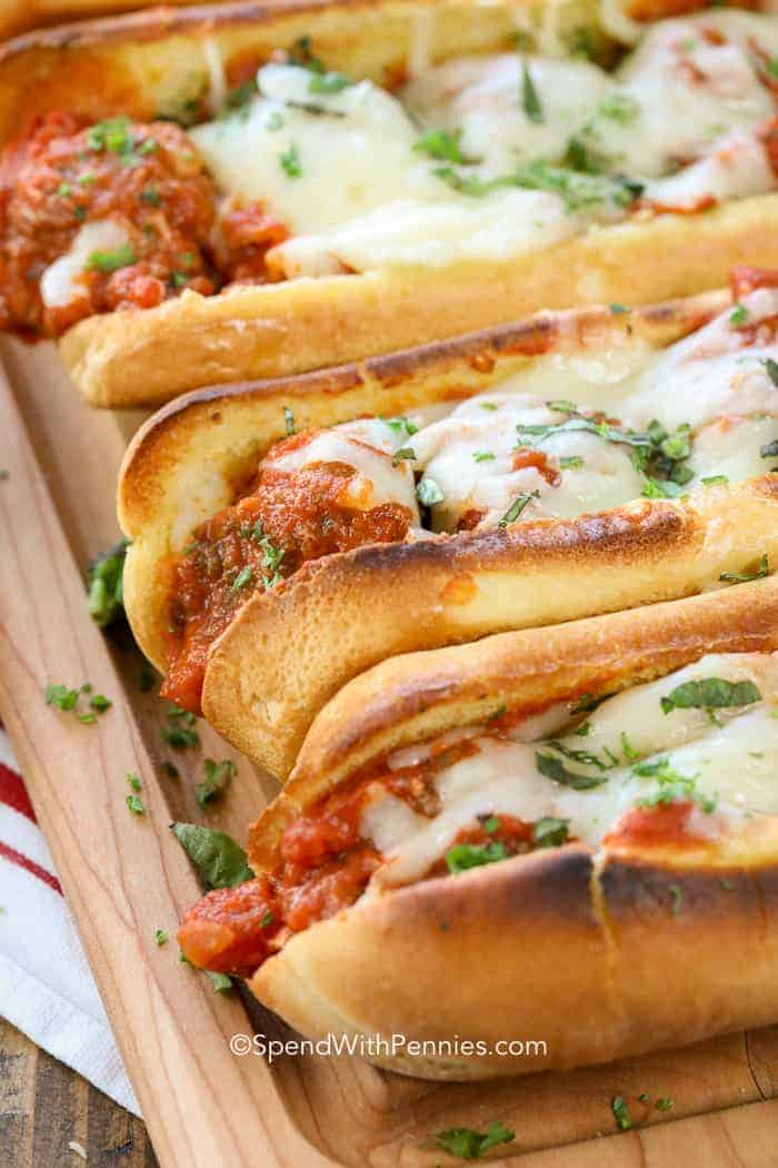 Three Meatball Subs on a wooden board