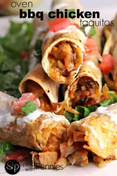a stack of Oven BBQ Chicken Taquitos with cheddar garnished with sour cream and tomatoes