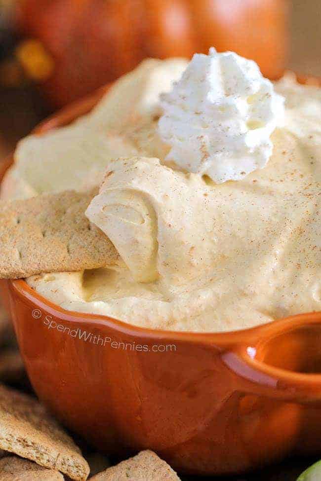 Pumpkin Pie Dip in an orange bowl with a cracker in it