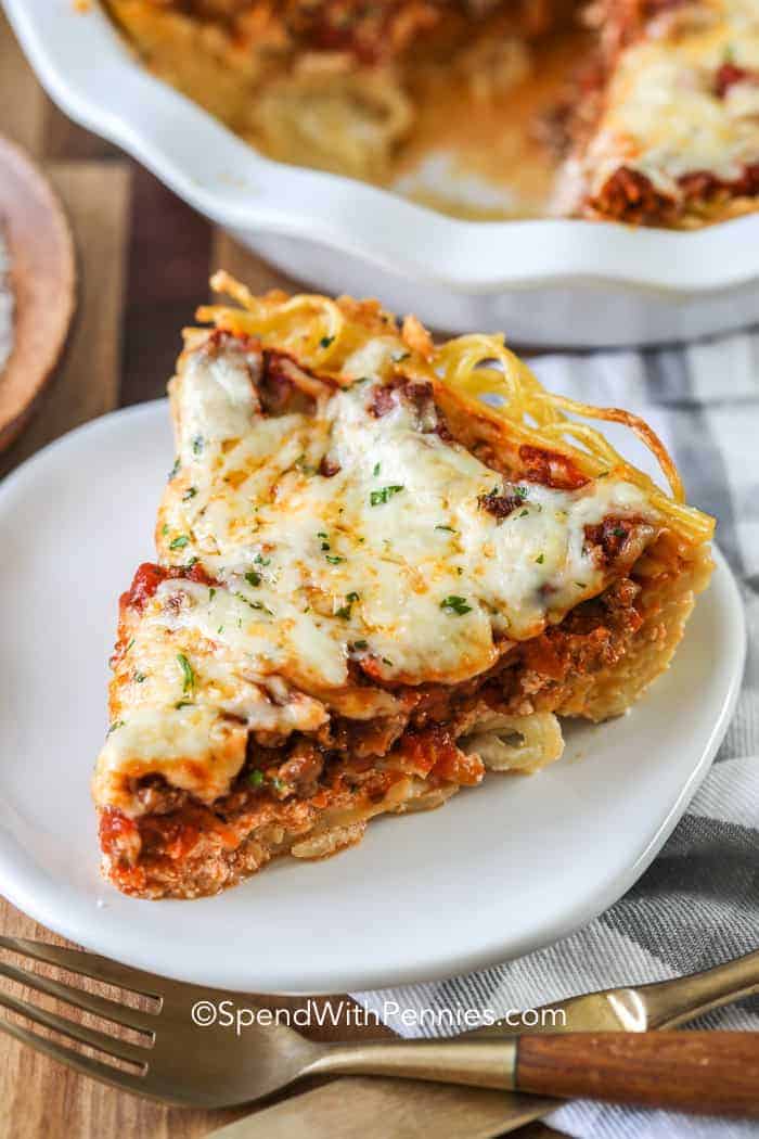 Piece of spaghetti pie on a white plate with a fork