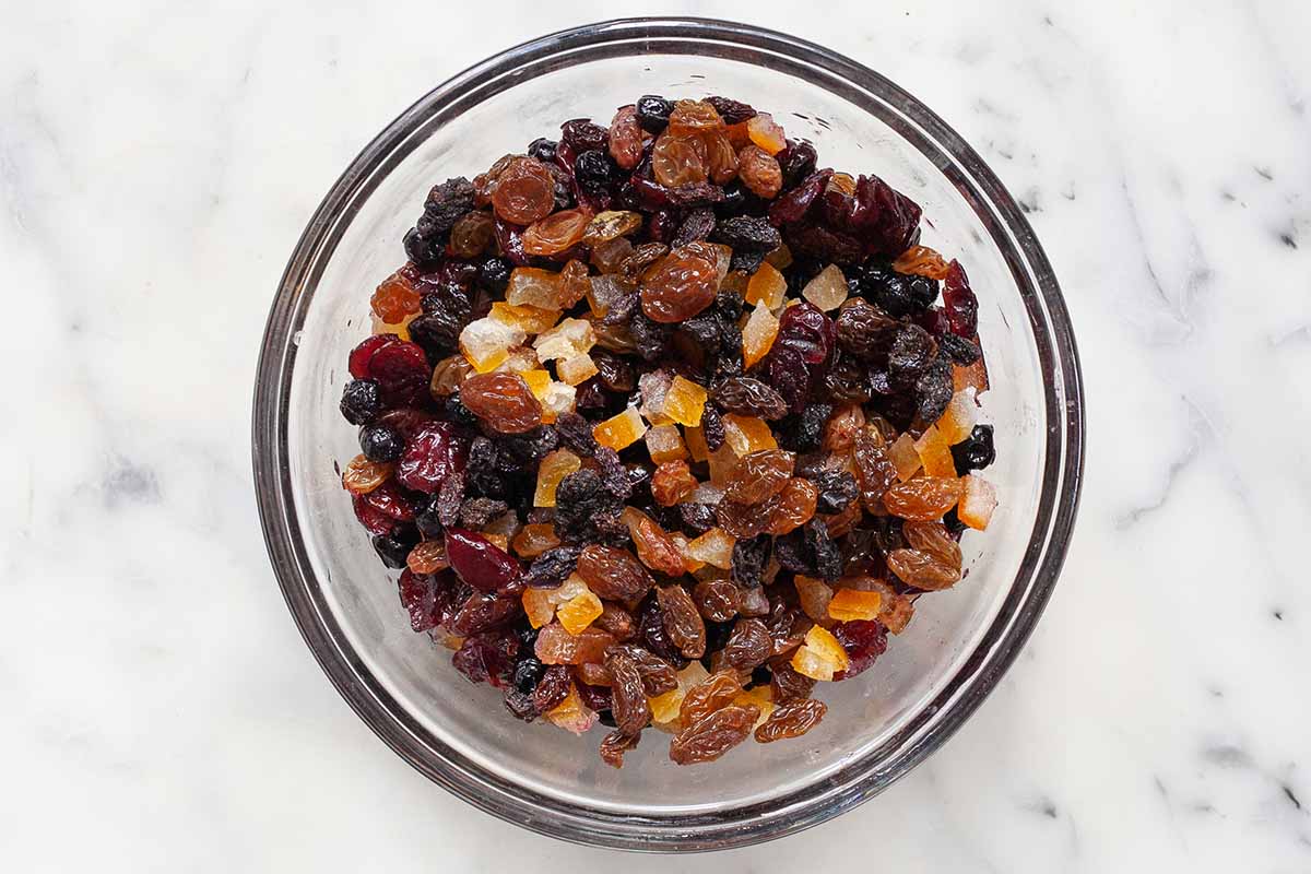 Mix di frutta secca e imbevuto di rum per pane di Natale tedesco Stollen in una ciotola di vetro.