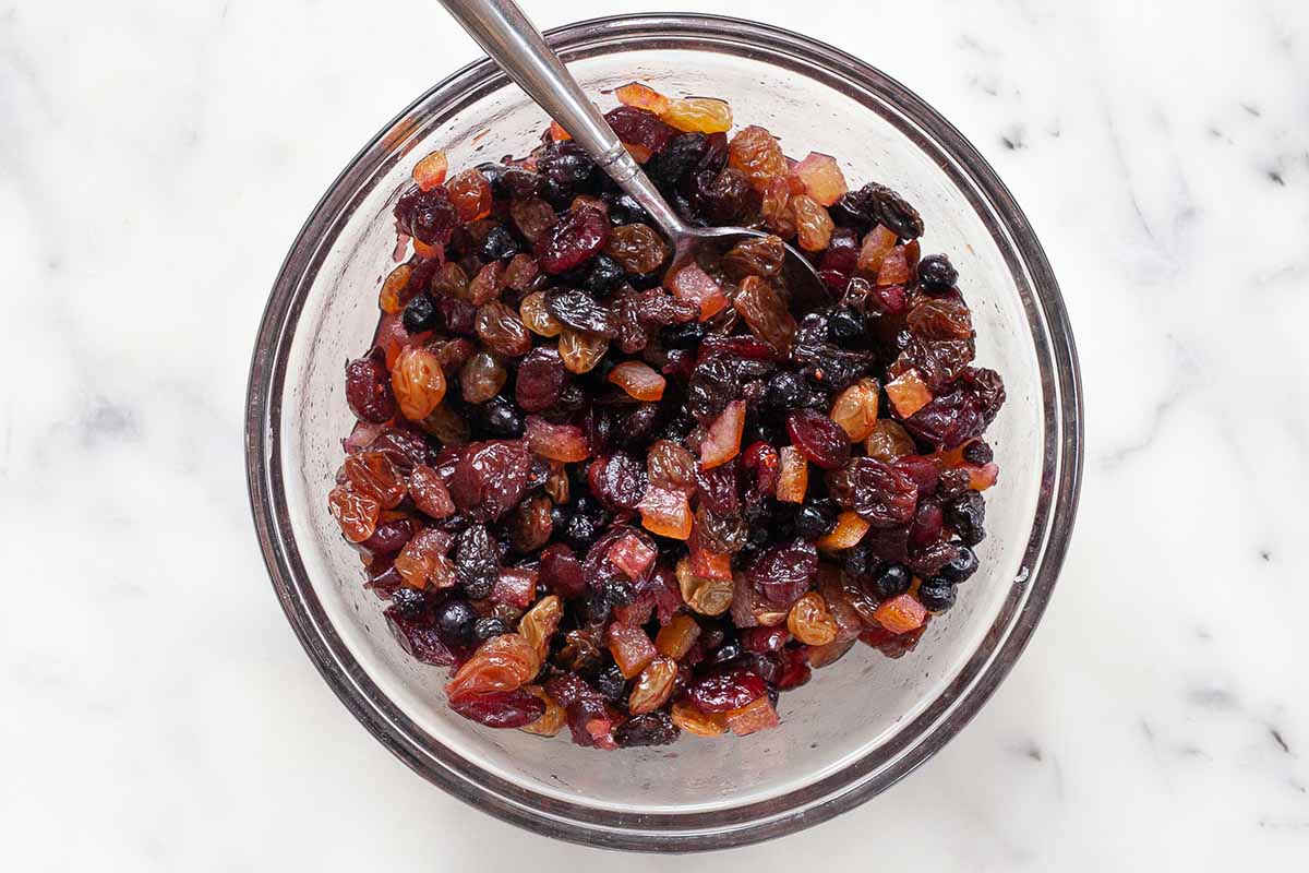 Mix di frutta secca e imbevuto di rum per pane di Natale tedesco Stollen in una ciotola di vetro.