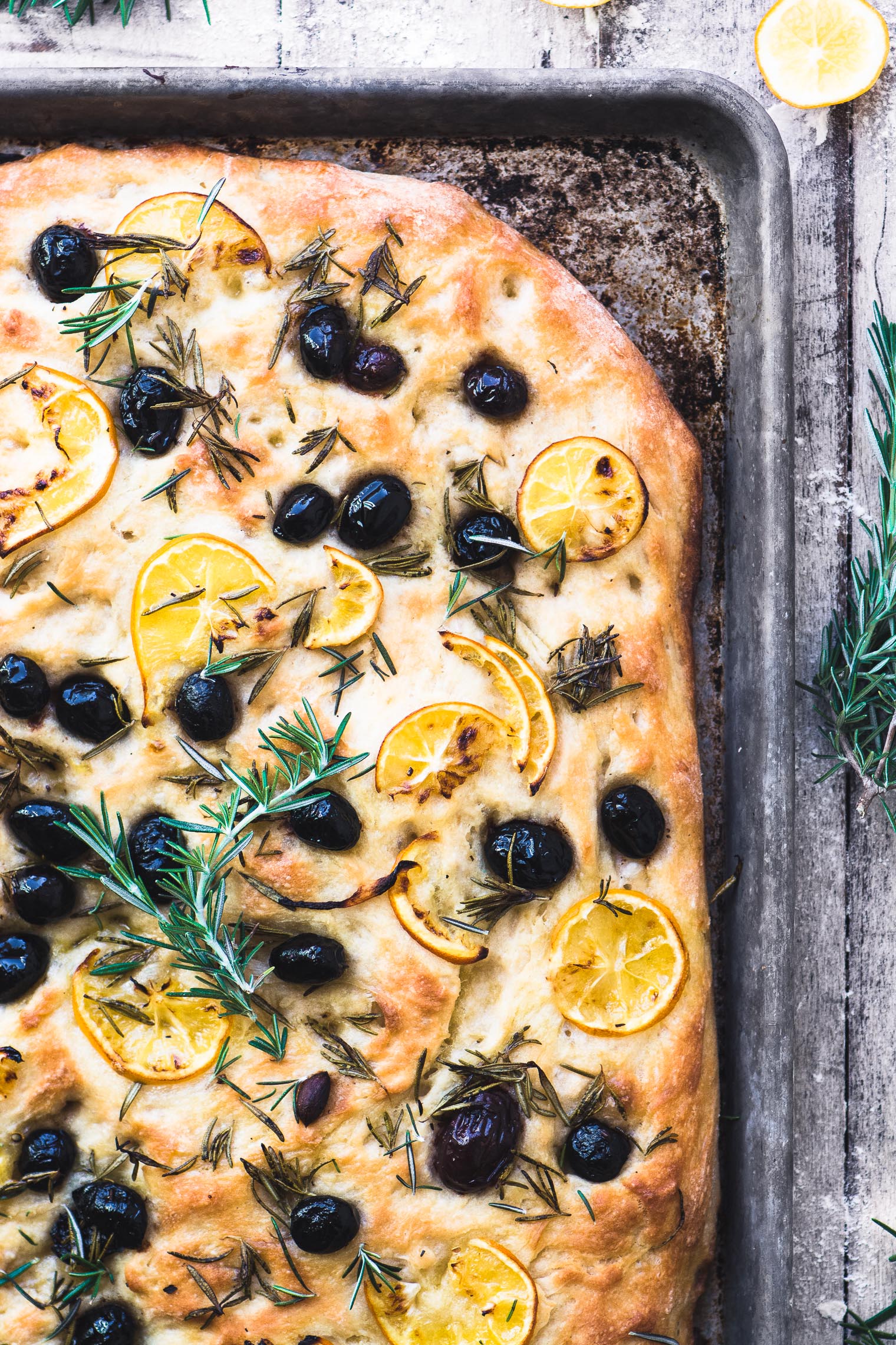 Focaccia Meyer non mescolata al rosmarino e alle olive La focaccia al limone sottile è un pane a lievito veloce che tornerà ancora e ancora. . Rosmarino e olive senza impastare focaccia su una teglia