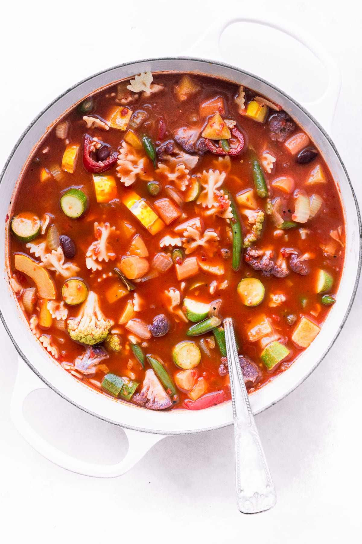Minestra classica di minestrone in una pentola bianca