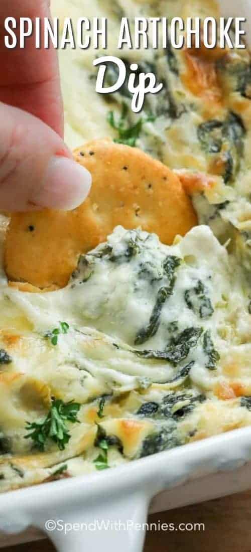 Salsa de alcachofa y espinacas en una fuente blanca para hornear y sacar con una galleta