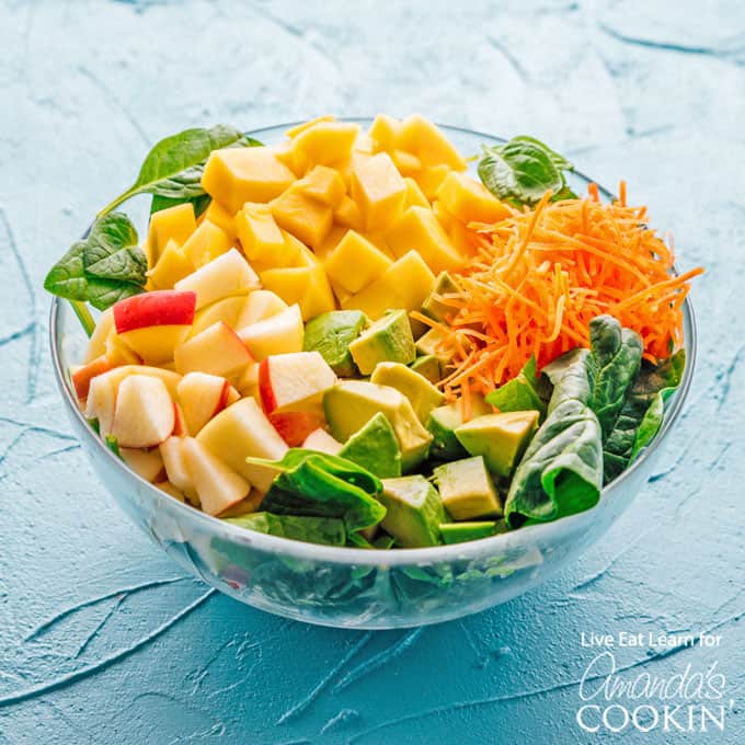 Insalata di spinaci con avocado, mango, carote e mele in ciotola