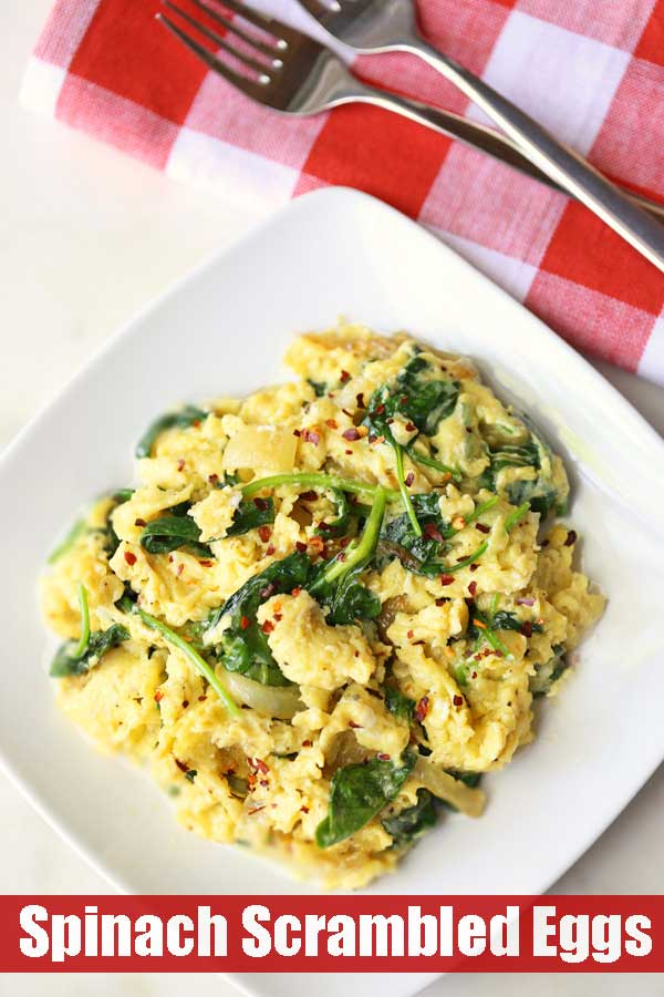 Uova strapazzate e spinaci serviti su un piatto bianco