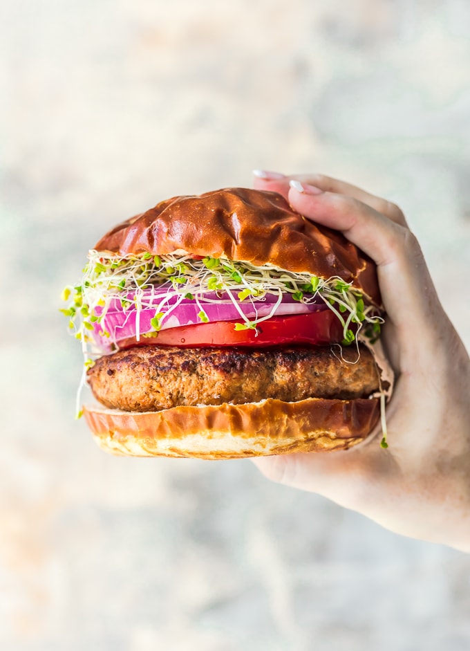 una mano che tiene un hamburger di tacchino
