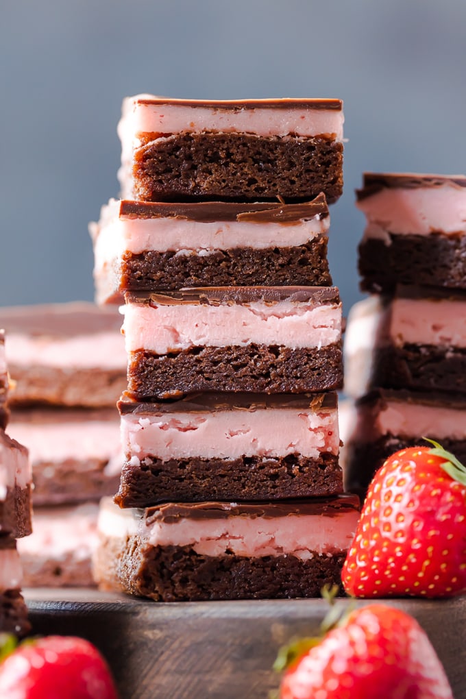¡LOS BROWNIES DE FRESAS son perfectos para el Día de San Valentín! Esta receta de brownie de fresa cubierto de chocolate es una mezcla de brownie de chocolate suave, relleno cremoso de fresa y una capa de chocolate derretido. Una pila de brownies de fresa