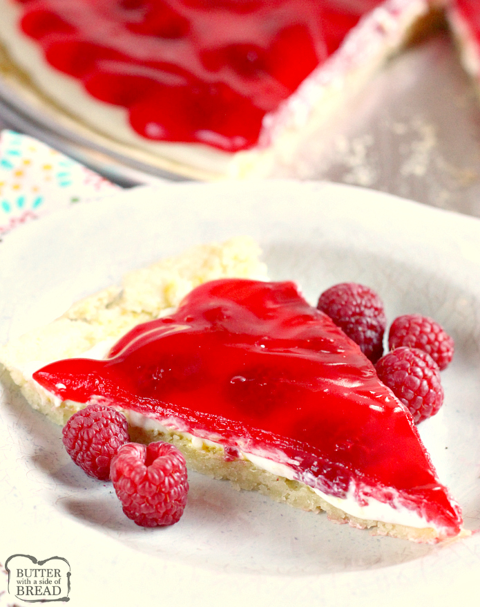 La pizza alla frutta al limone e lampone è fatta con una crosta di biscotti allo zucchero al limone condita con uno strato di crema di formaggio, lamponi freschi e una deliziosa glassa di lamponi! Questa ricetta per la pizza alla frutta è molto semplice da preparare usando un mix di biscotti al limone e la glassa è fatta con gelatina di lamponi!