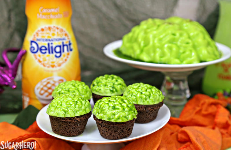 Zombie Brain Brownie Bites - con un grande cervello verde dietro e una bottiglia di crema al caffè al caramello | Da SugarHero.com