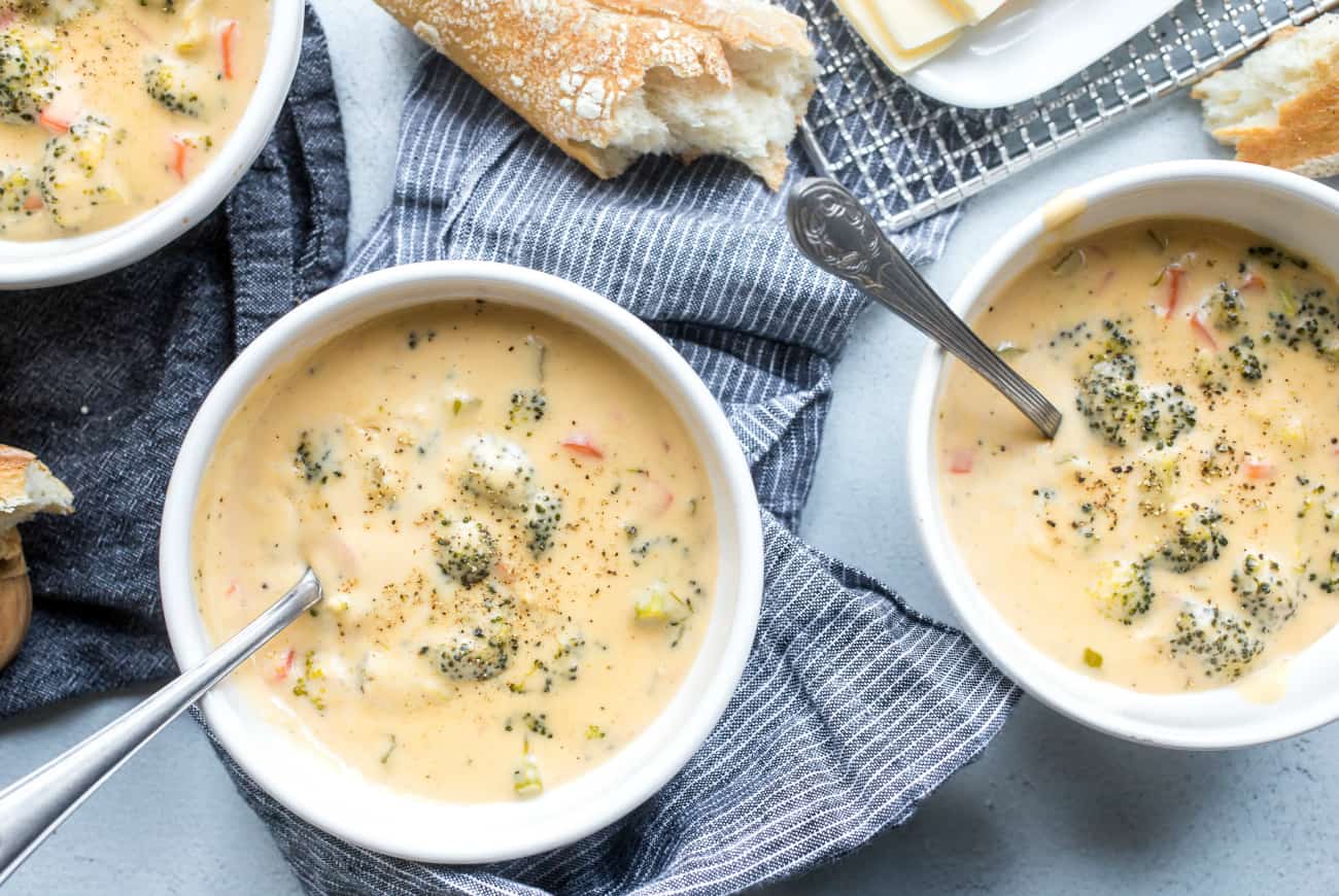 Colpo ambientale delle ciotole di minestra di broccoli e di formaggio accanto a pane croccante
