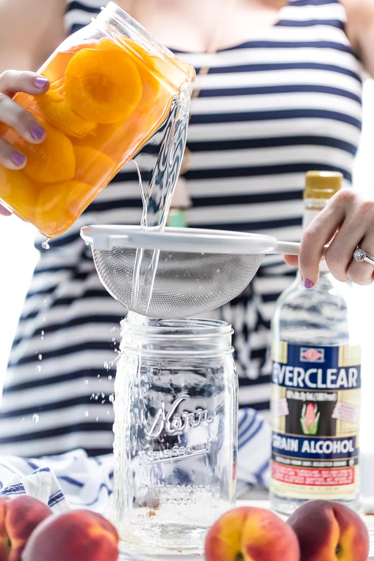 versare la vodka alla pesca attraverso un colino