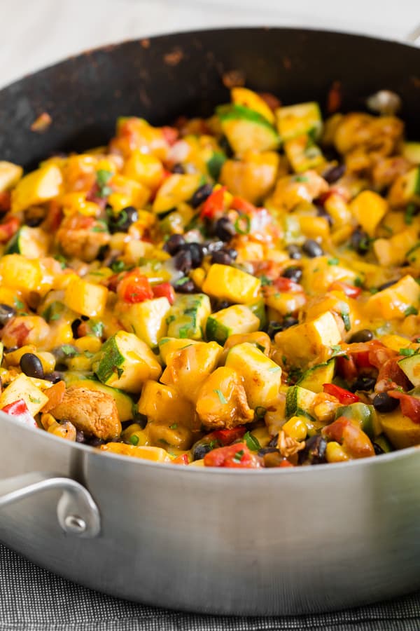 Questa padella Tex Mex di pollo e verdure è pronta in soli 30 minuti ed è un ottimo modo per usare tutte quelle verdure estive. È ricco di zucchine, zucca gialla, mais dolce estivo, peperoni, pollo condito e condito con la giusta quantità di formaggio cheddar Cabot Havana piccante. Servire da solo o pieno di riso. Ad ogni modo, è assolutamente delizioso!