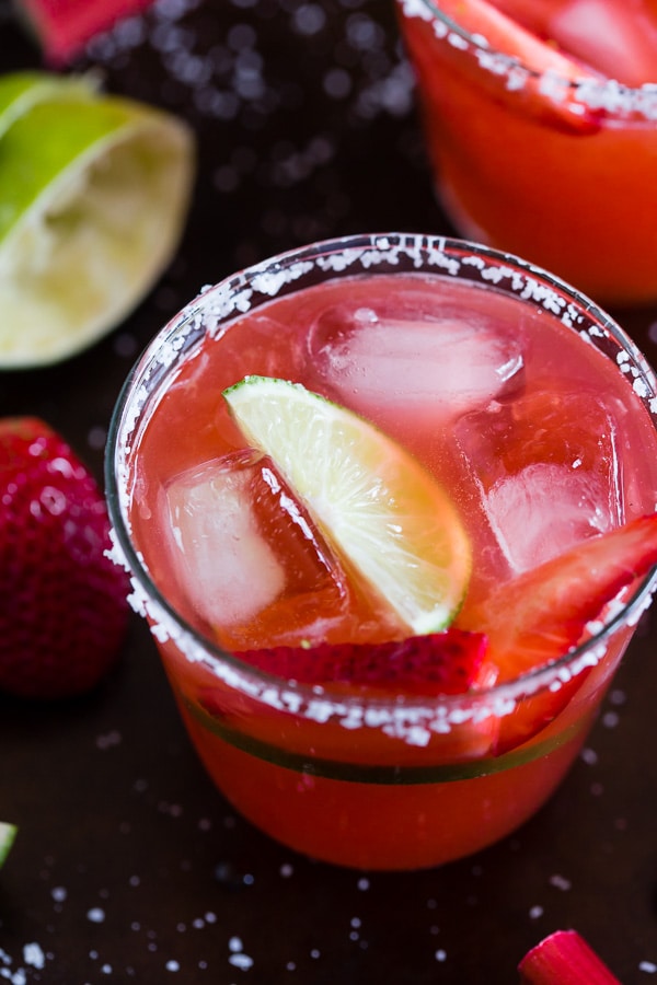 Questa margarita al rabarbaro e fragola è il modo perfetto per celebrare la primavera e il Cinco de Mayo. Il perfetto equilibrio tra dolce, crostata e tequila! Realizzato con sciroppo di rabarbaro alla fragola fatto in casa e servito perfettamente freddo sulle rocce con un bordo salato. Saluti al tuo nuovo drink estivo! 