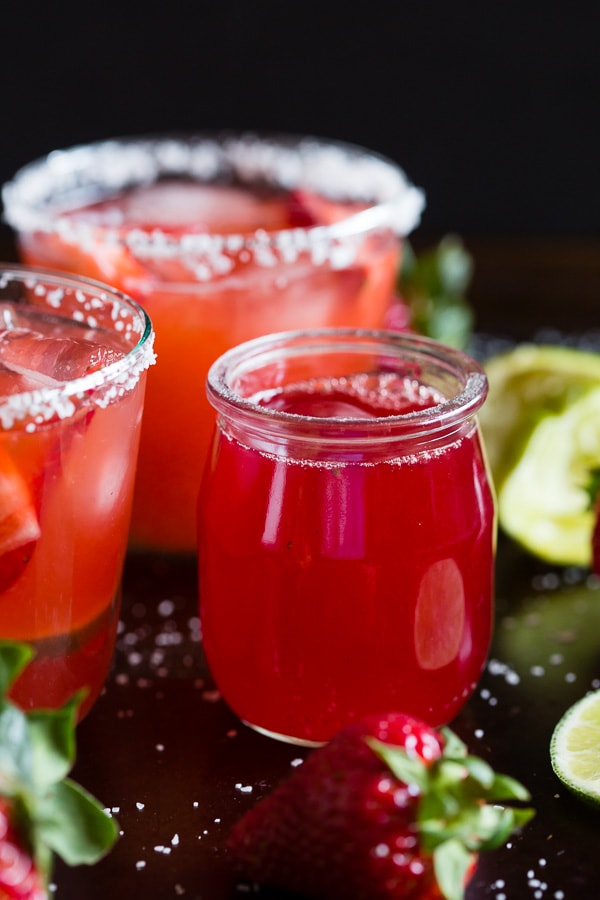 Questa margarita al rabarbaro e fragola è il modo perfetto per celebrare la primavera e il Cinco de Mayo. Il perfetto equilibrio tra dolce, crostata e tequila! Realizzato con sciroppo di rabarbaro alla fragola fatto in casa e servito perfettamente freddo sulle rocce con un bordo salato. Saluti al tuo nuovo drink estivo! 